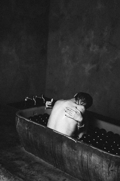 赤裸上身的男人在浴缸里喝水